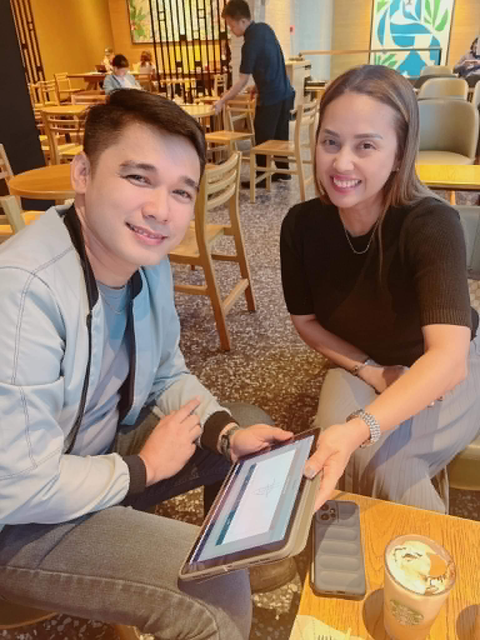 Ruth Abestilla walking a client through his plan on a tablet at a coffee shop