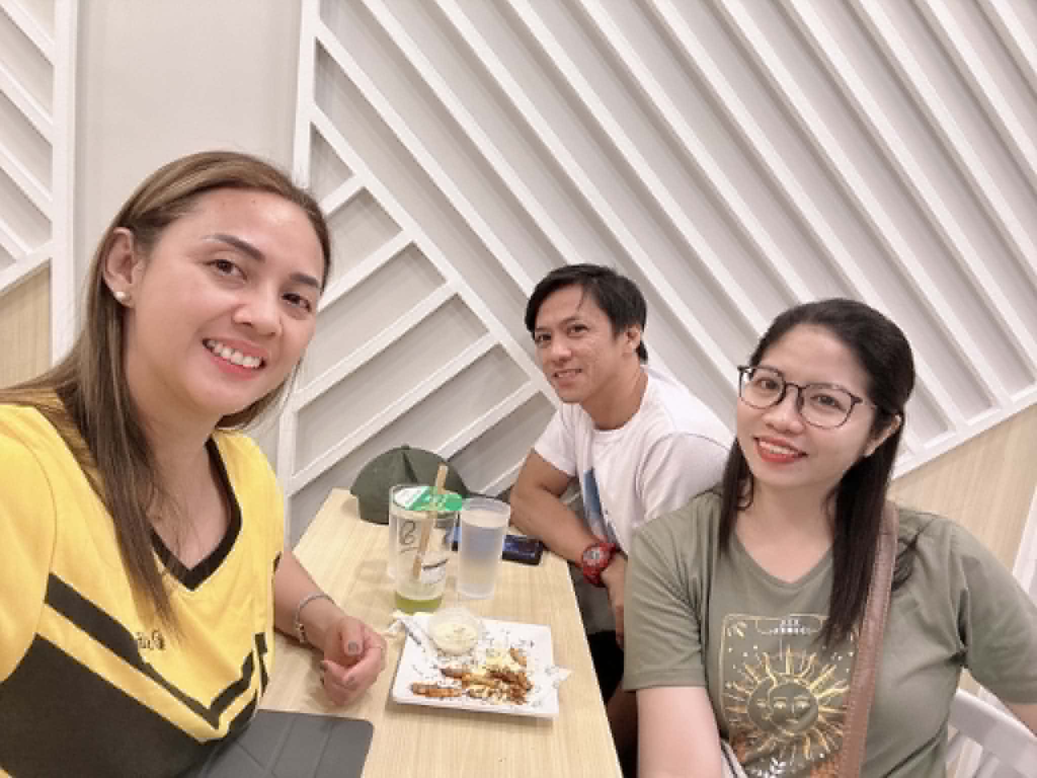 Ruth Abestilla in her Sun Life shirt sharing merienda with two clients at a restaurant